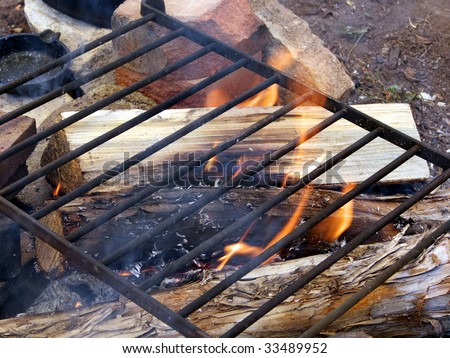 Cooking on an open fire on a metal grate in pioneer fashion
