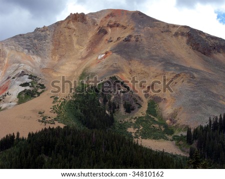 Mountain top with iron ore trailing down to the treeline
