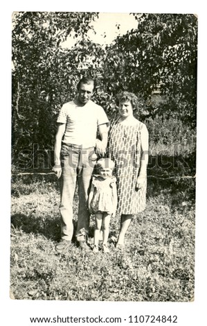 Central Bulgaria, BULGARIA, CIRCA 1955 - mother, father and girl child posing in the garden - circa 1955