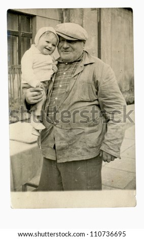 Central Bohemia, CZECHOSLOVAKIA, CIRCA 1950 - Grandfather holds his granddaughter in his arms (a village near Prague) - circa 1950
