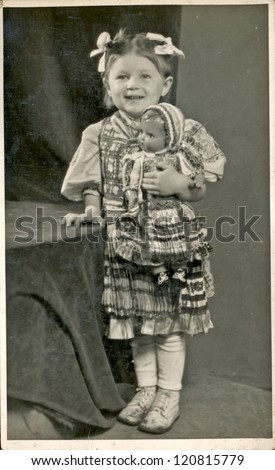 CZECHOSLOVAKIA, CIRCA 1950 - Girl posing in the national costume in a photographic studio (holding porcelain doll) - Circa 1950