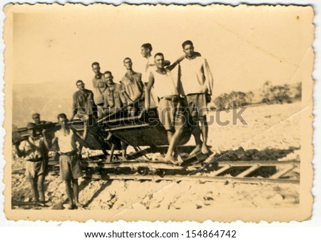 CENTRAL BULGARIA, BULGARIA - CIRCA 1950: Group of young men, probably soldiers, in trucks on rails - Note: slight blurriness, better at smaller sizes - circa 1950
