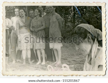 CENTRAL BULGARIA, BULGARIA - CIRCA 1960: Group of middle-aged people singing (female head in foreground) - Note: slight blurriness, better at smaller sizes - circa 1960