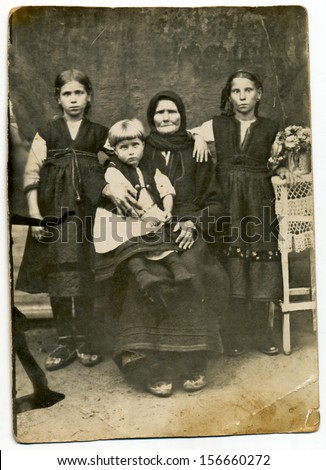 CENTRAL BULGARIA, BULGARIA, district Plovdiv - CIRCA 1930: Traditional family in period dress (here an old woman and two girls, one boy) - Note: slight blurriness, better at smaller sizes - circa 1930