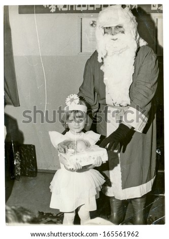 CENTRAL BULGARIA, BULGARIA - CIRCA 1980 - In kindergarten, Santa Claus (Papa Frost or Papa Noel) visited the kid (a girl) - Note: slight blurriness, better at smaller sizes - circa 1980