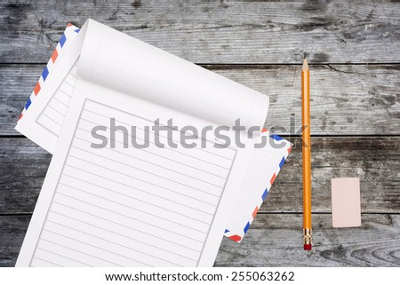 letter paper, rubber and pencil on wooden table background