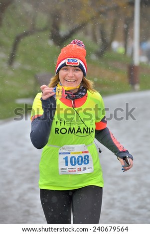 BUCHAREST, ROMANIA - DECEMBER 1st: Cute unidentified marathon runner showing medal and competes while snowing, at the National Day of Romania Marathon 2014, December 1st, 2014 in Bucharest, Romania