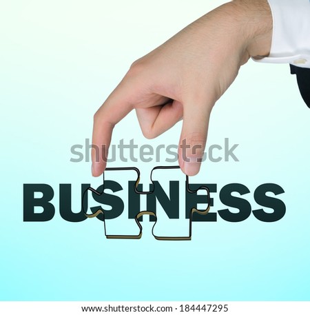 A hand holding a business puzzle piece.