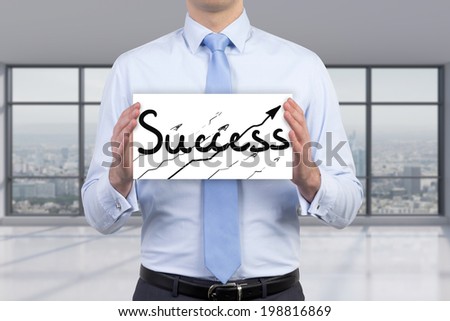 Businessman holding a poster \'success\'