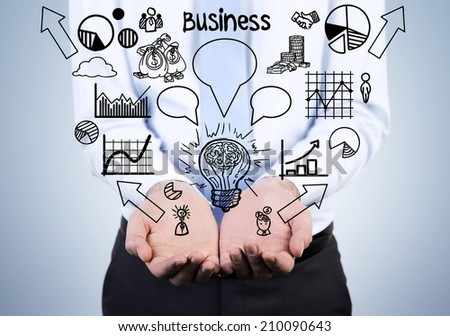 Young businessman holding a set of the graphs including pie chart, line graph, sketches etc. Business development concept.