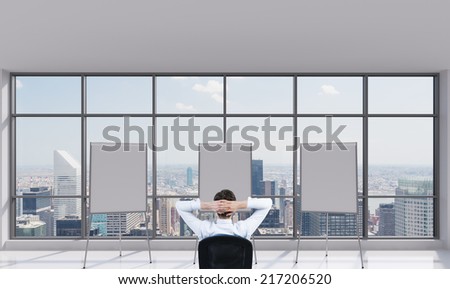 A concept of three possible choices of the project business development. Three whiteboards in a modern panoramic office and thinking businessman.