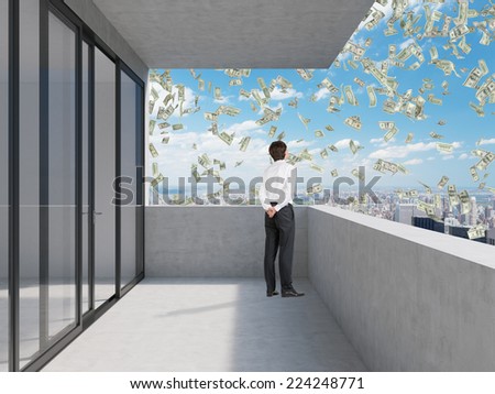 Businessman standing on the balcony and looking at falling dollars.