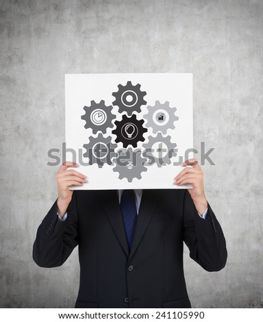 businessman holding poster with drawing cogs and gears