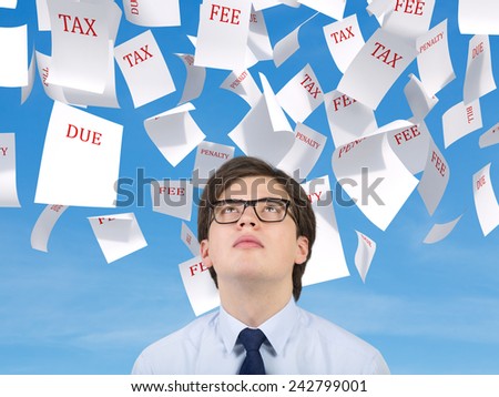 young businessman looking to falling tax papers