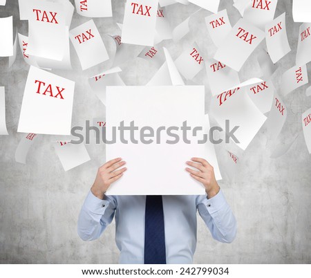 businessman holding poster and to falling tax papers