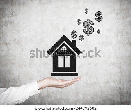hand holding drawing house with dollars