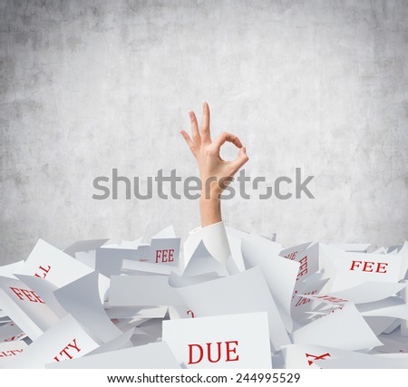 hand showing OK symbol  and falling tax papers