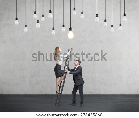 Businessman holds a ladder for the business lady. The concept of the teamwork and cooperation.