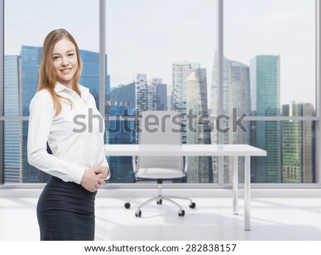 Portrait of a beautiful business lady in a contemporary office with Singapore panoramic view.