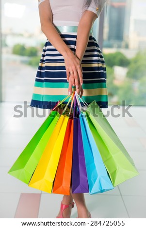 Woman holding colourful shopping bags at the mall.