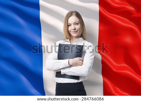 Smiling business lady in a white shirt with a black folder. French flag as a background.
