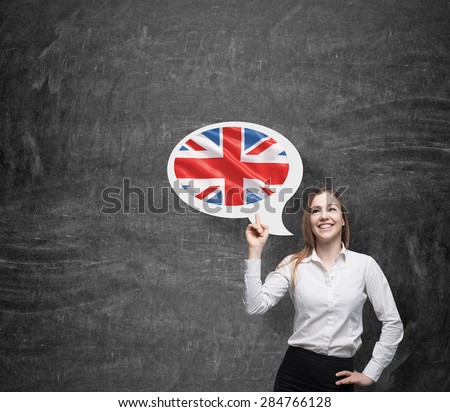 Beautiful woman is pointing out the thought bubble with Great Britain flag. Dark background.