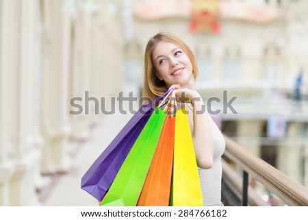 A happy smiling young lady with a lot of colourful shopping bags from the fancy shops.