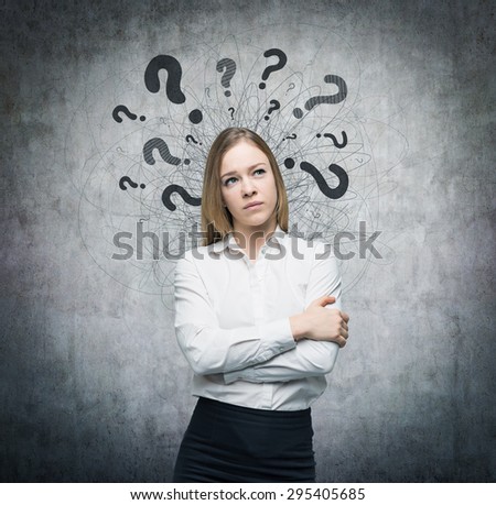 A portrait of a beautiful lady with questioning expression and question marks above her head. Concrete background.
