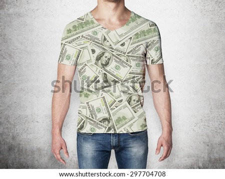 Close-up of a man in a t-shirt crafted from dollar notes. Concrete background.