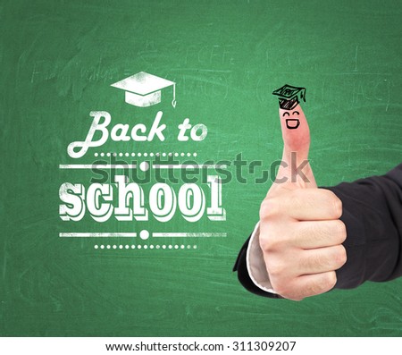 A thumb up with the sketch of the graduation hat and the words: \' back to school \' which are written on the green chalkboard.