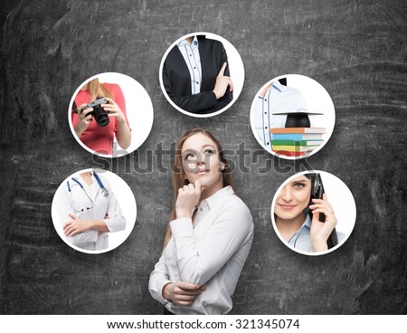 A beautiful young lady in a formal shirt is thinking about different professions. Black chalkboard as a background.