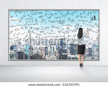 Rear view of business lady who is drawing math formulas on the New York panoramic poster. A room with concrete wall and floor.