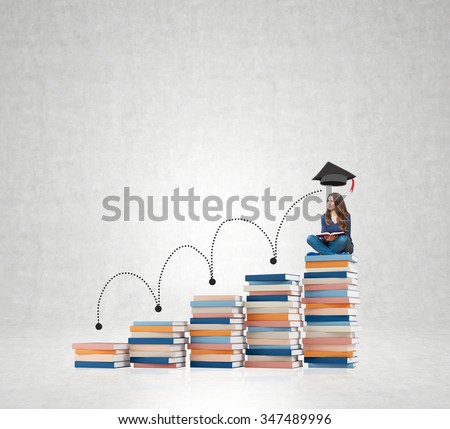 young woman sitting on a pile of books thickest out of five with a book on knees thinking about future education, white wall at the back, concept of dreaming and growth