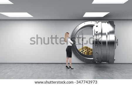 young woman standing in front of a big unlocked round metal safe in a bank depository with a pyramid of gold bars and lock-boxes inside,  a concept of security and client service
