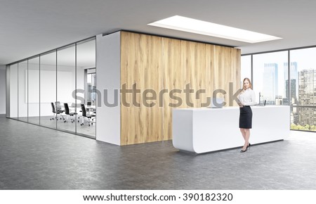 Office, white reception at wooden wall. Businesswoman in front. Panoramic window right, meeting room behind. Concept of reception.