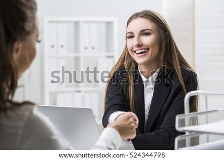 Woman Smiling HR department employee is greeting a candidate by shaking her hand. Concept of communication