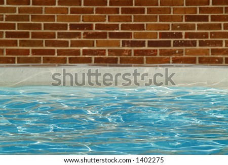 a swimming pool surrounded by a brick wall