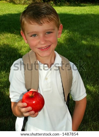 boy taking an apple for his teacher on the first day of school
