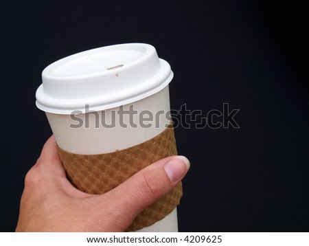 a female\'s hand holding a disposable paper coffee cup