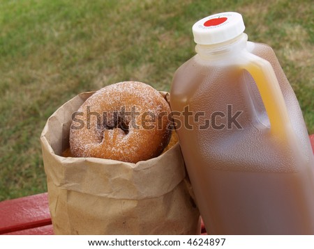 a half-gallon of apple cider alongside a bag of cinnamon-sugared donuts