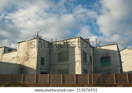 old,vacant factory behind a fence