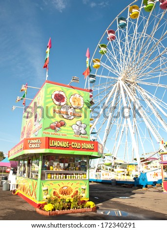 fried food stand and ferris wheel on a fair midway
