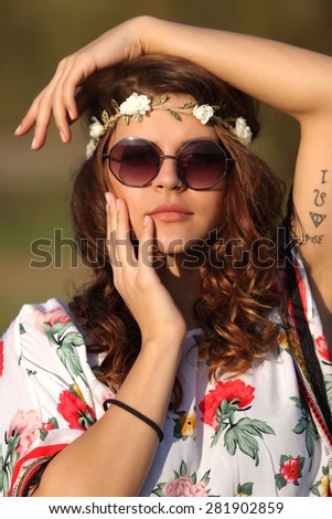 Sexy hippie woman in sunglasses and with a wreath on his head Outdoors
