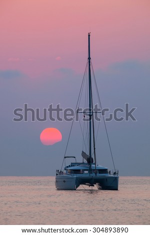 Sailing catamaran on a background of a beautiful sunset in the sea Outdoors