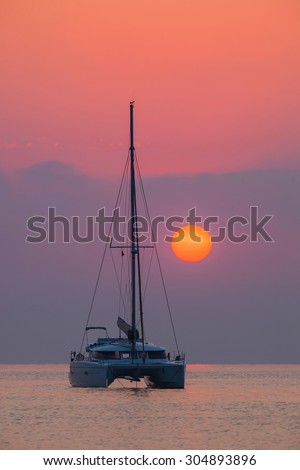 Sailing catamaran on a background of beautiful sunrise in the ocean Outdoors