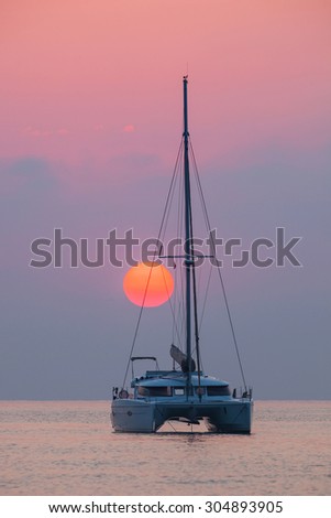 Sailing catamaran on the background of the rising sun on the sea Outdoors