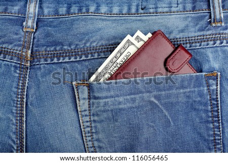 money dollars and brown leather wallet in jeans back pocket blue color background