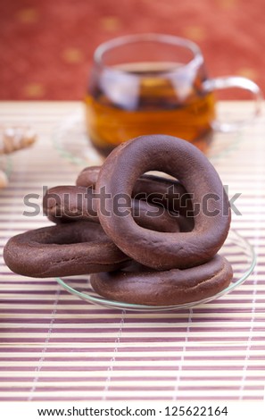 plate with pretzel next to a cup of tea studio shot
