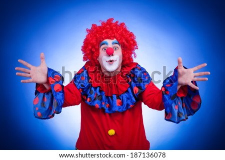Happy clown on blue background. Studio professional lighting