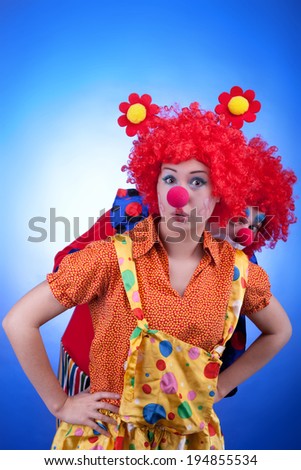 Clown couple in costumes on blue background. Studio professional lighting. Vibrant colors